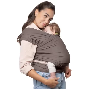 Parent wrapping a newborn snugly in a soft fabric baby wrap.